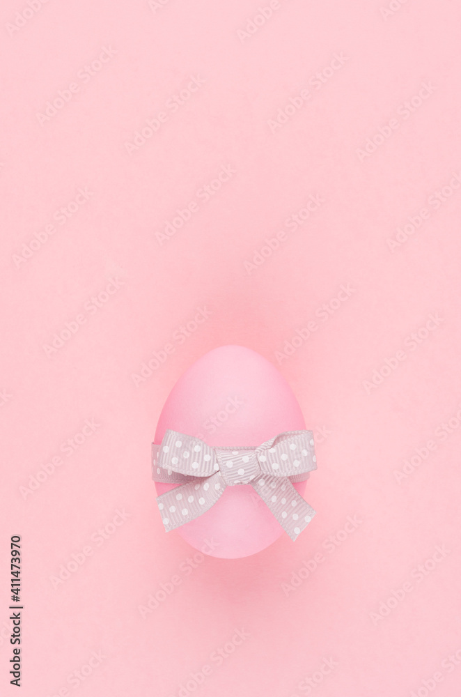Simplicity and purity easter background - egg with grey ribbon on pink pastel color, vertical. Simplicity and purity easter background - egg with grey ribbon on pink pastel color, vertical.