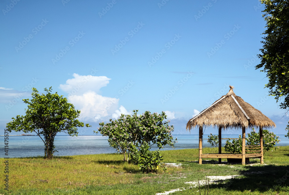 wooden bungalow by the sea with a green tree on blue sky background wooden bungalow by the sea with a green tree on blue sky background