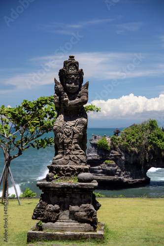 statue in a buddhist temple on blue sky with clouds and sea water background © KANSTANTSIN
