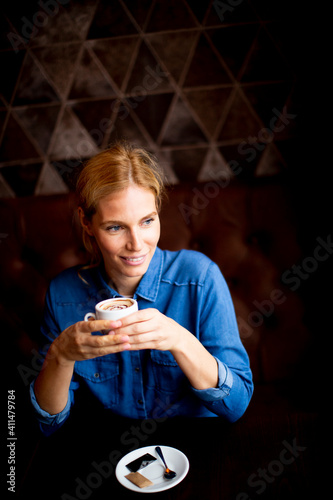 Smiling young woman drinkin...