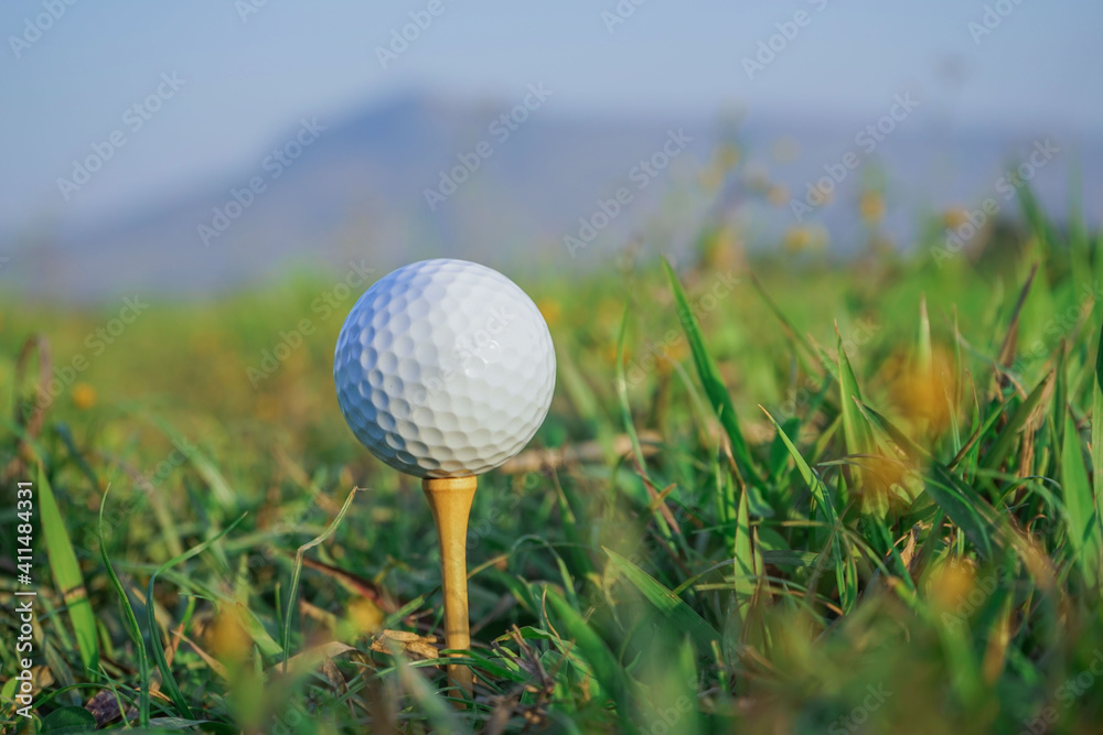 Golf ball on tee ready to play in the evening golf course with sunshine. Golf ball on tee ready to play in the evening golf course with sunshine.