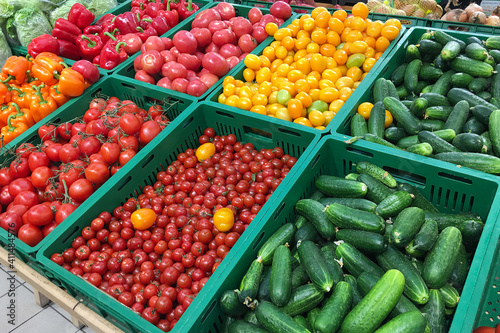 Cucumbers, tomatoes and bell peppers are sold at the grocery store. Vegetables on the market. 