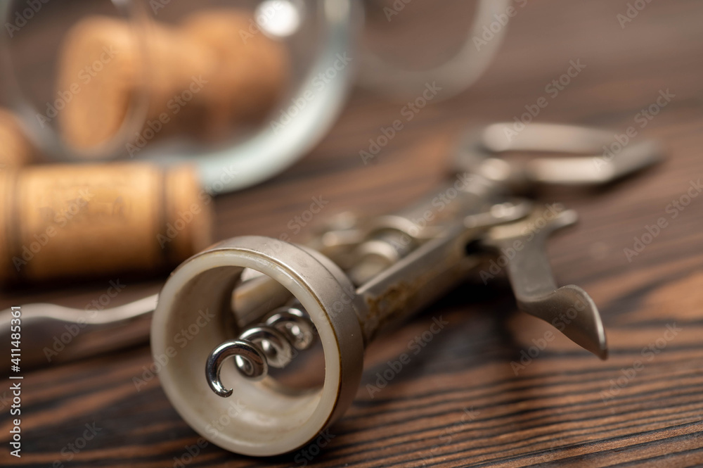 Corkscrew and corks from wine bottles on a wooden table. Corkscrew and corks from wine bottles on a wooden table.