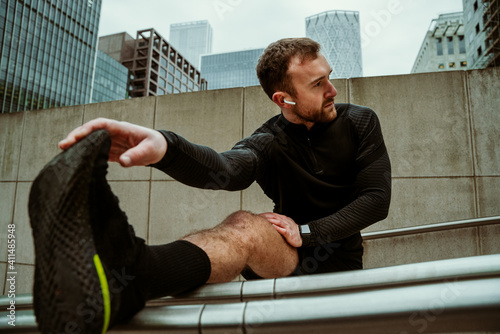 Photography Handsome caucasian male athlete stretching legs running in city exercising for f