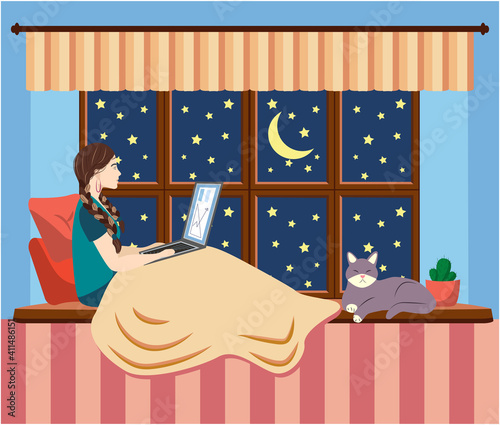 A woman works at a laptop while sitting on the windowsill at home. Freelance concept, quarantine due to covid-19.
