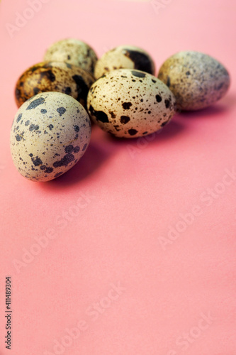 six raw quail eggs lie in the woman's right hand on an orange background on the side