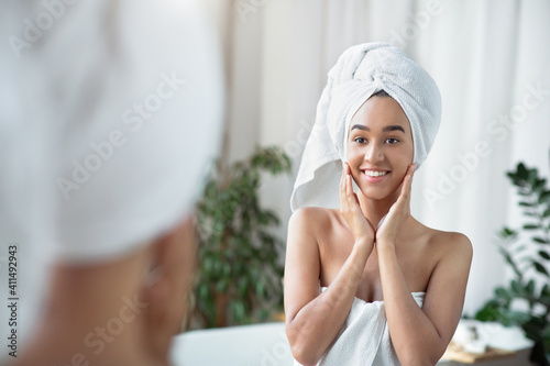 Happy african american lady satisfied with moisturized soft tender skin condition after care