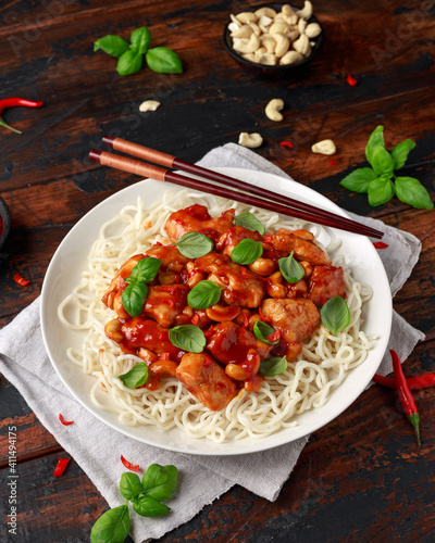 Sweet Chilli Chicken with noodles on wooden table. asian food