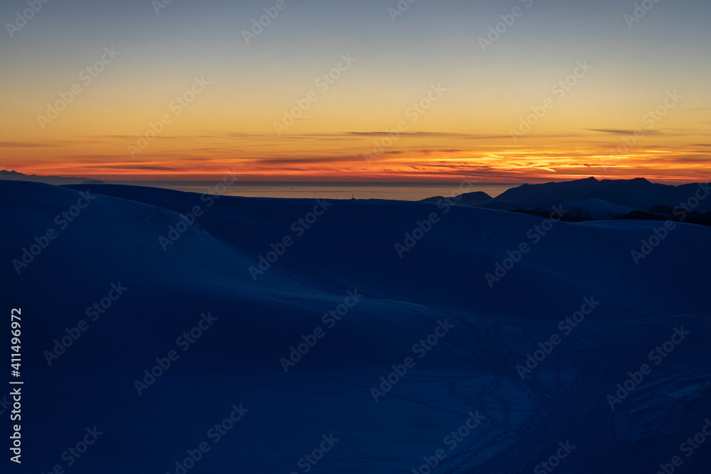 tramonto con neve e mare