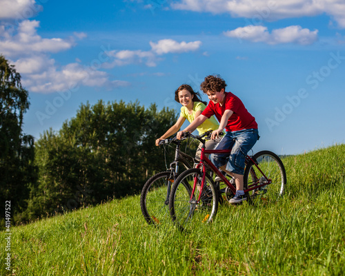 Healthy lifestyle - teenage girl and boy riding bicycles
