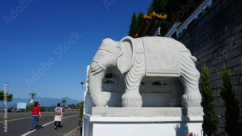 two hikers and an elephant statue at the Xuan Zang Temple, Sun Moon Lake, Yuchi Township, Nantou County, Taiwan, January photo