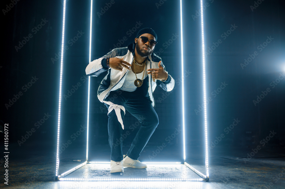 Stylish rapper in gold jewelry and sunglasses - obrazy, fototapety, plakaty 