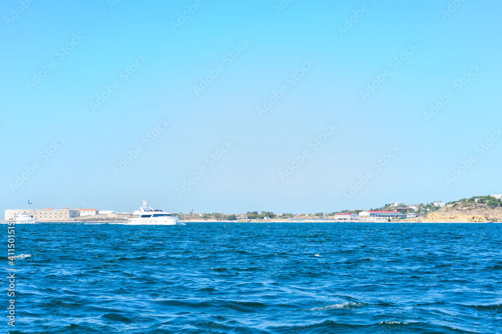 Coastline and waves in the sea, sunny Crimean summer. Horizontal orientation