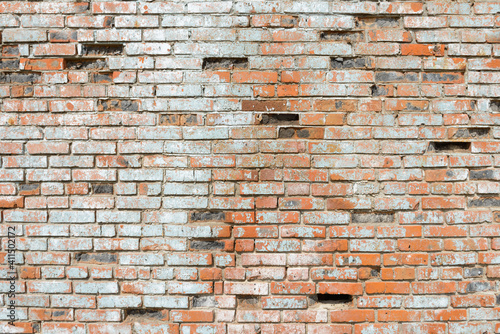 old crumbling brick wall made of ceramic red brick
