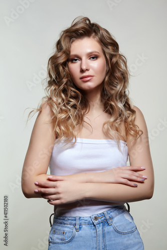 Portrait of young blonde female with hands crossed.