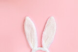 Funny Easter bunny ears isolated on pastel pink background. Top view with space for text