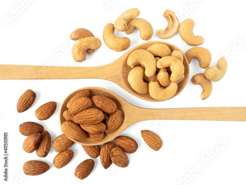 Organic almonds and cashew nuts in wooden spoon and heap almonds and cashew isolated  top view on white background for almond nuts can improve health concept.