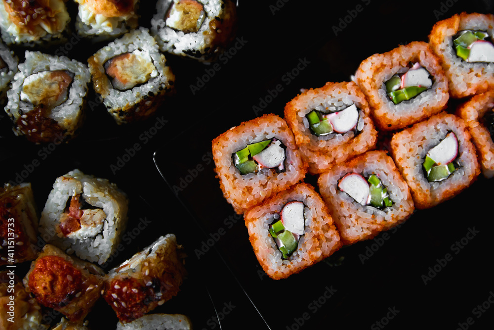 Fresh sushi rolls set on gark background Fresh sushi rolls set on gark background