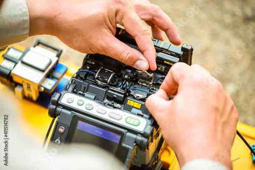 Fiber Optic Fusion Splicing Cable checking signal and Wire connection with Fiber Optic Fusion Splicing machine.The technician is checking the fiber optic cable photo