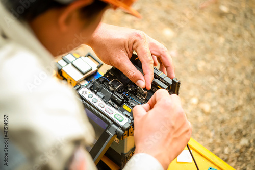 Fiber Optic Fusion Splicing Cable checking signal and Wire connection with Fiber Optic Fusion Splicing machine.The technician is checking the fiber optic cable