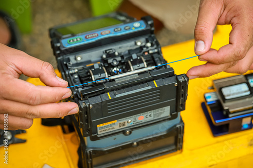 Fiber Optic Fusion Splicing Cable checking signal and Wire connection with Fiber Optic Fusion Splicing machine.The technician is checking the fiber optic cable