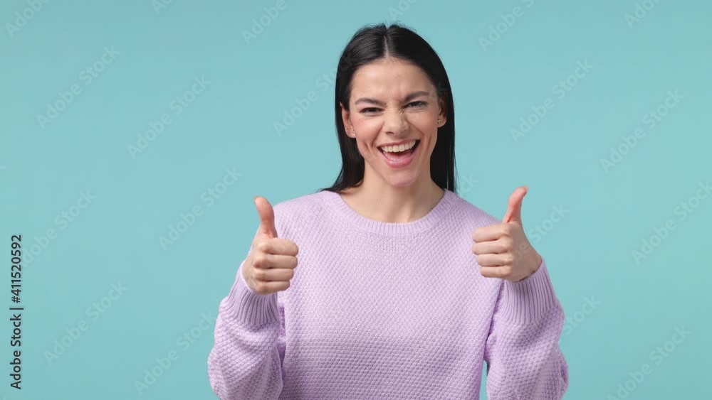 Back rear view of cheerful brunette young latin woman 20s in pastel violet sweater posing isolated on blue background studio. People lifestyle concept. Turn around camera showing thumb up like gesture Back rear view of cheerful brunette young latin woman 20s in pastel violet sweater posing isolated on blue background studio. People lifestyle concept. Turn around camera showing thumb up like gesture