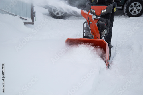 A portable snow blower powered by gasoline. Snow removal in winter. photo