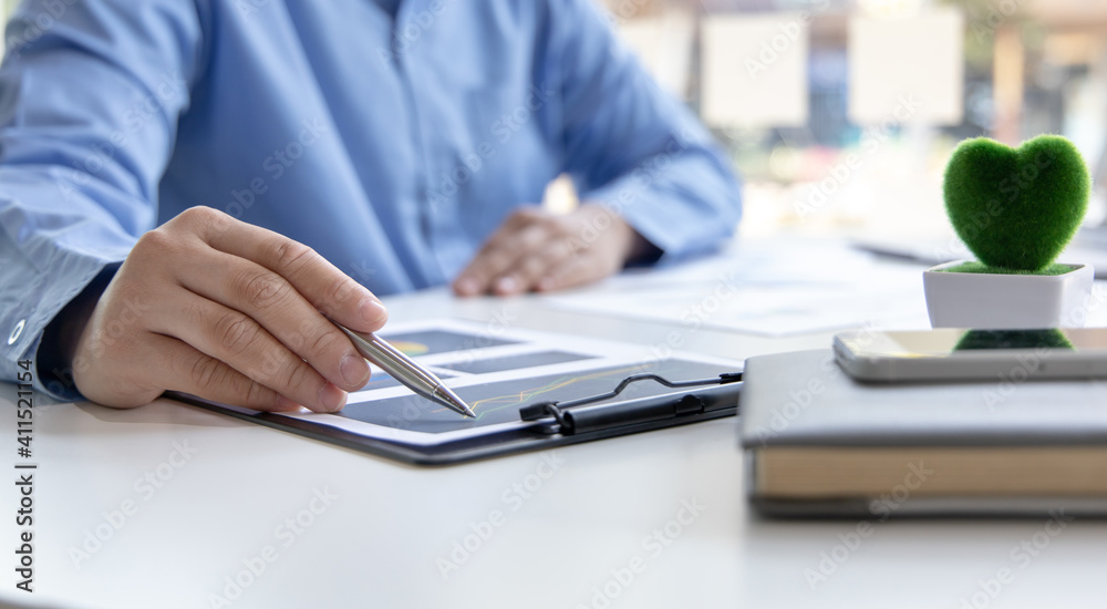 Fototapeta premium Financial businessman analyze the graph of the company's performance to create profits and growth, Market research reports and income statistics, Financial and Accounting concept.