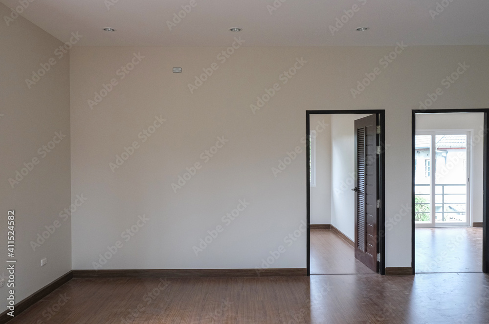 two room open brown door with white wall in new house. wooden laminate floor in living room. two room open brown door with white wall in new house. wooden laminate floor in living room.