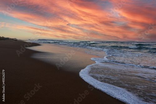 Fototapeta Naklejka Na Ścianę i Meble -  beautiful sunset with waves at Xeraco beach in Valencia, Spain