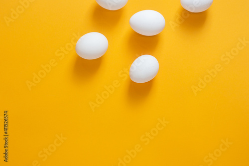 Chicken white eggs on a yellow background.