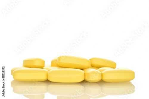 Several oval yellow pills, close-up, isolated on white.