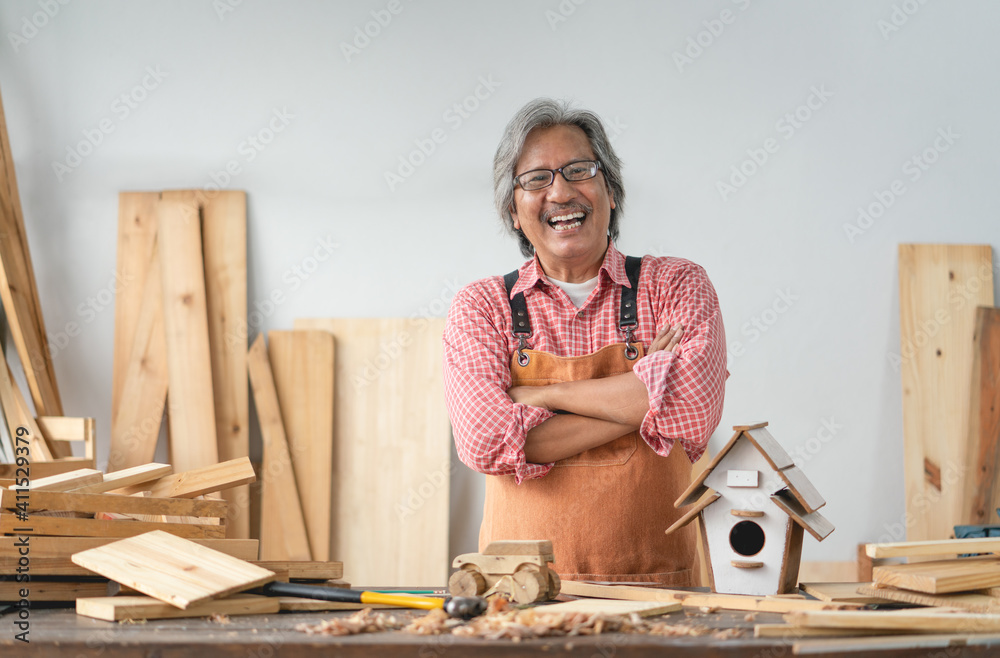 Asian senior carpenter man with crossed arms smile at home carpentry workshop - obrazy, fototapety, plakaty 