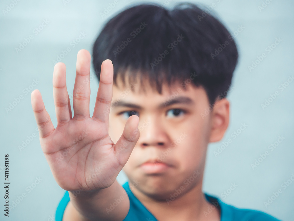 Asian boy doing stop sign with palm on white background. And standing with outstretched hand showing stop gesture. Asian boy doing stop sign with palm on white background. And standing with outstretched hand showing stop gesture.