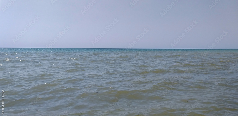 landscape: sea with small waves and distant horizon.