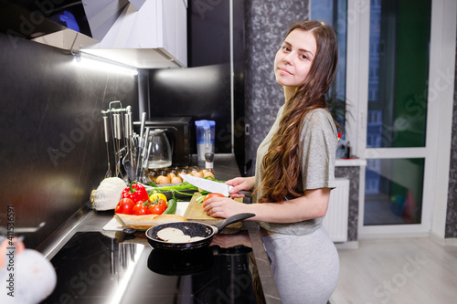 Young woman cooking vegetables in kitchen. Healthy Food. Dieting Concept. Healthy Lifestyle. Cooking at home. Prepare Food