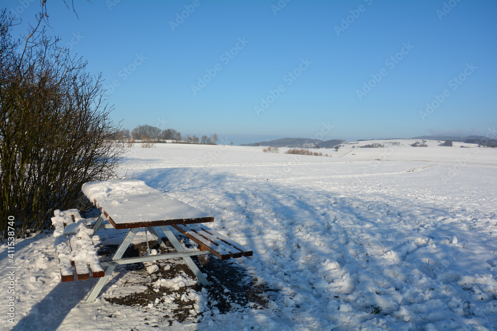 Landscape in the snow, with a table and benches Landscape in the snow, with a table and benches