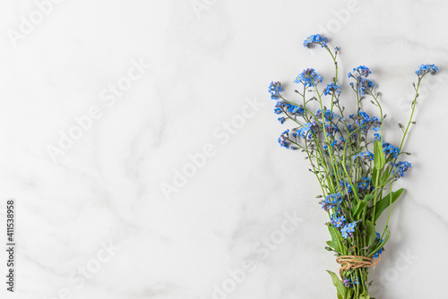 Forget me not flowers bouquet on white background with copy space. top view. flat lay. wedding or holiday concept