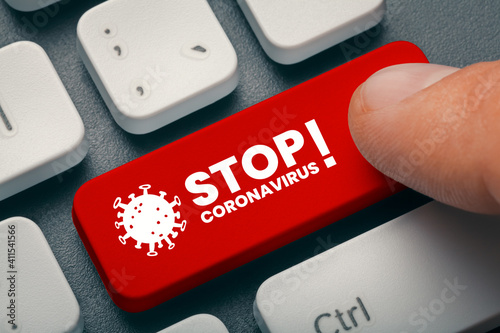 The UK Variant of mutated corona virus B117 hit the world. Pandemic Coronavirus concept. Close up finger pressing red computer key with stop coronavirus word and illustration. photo