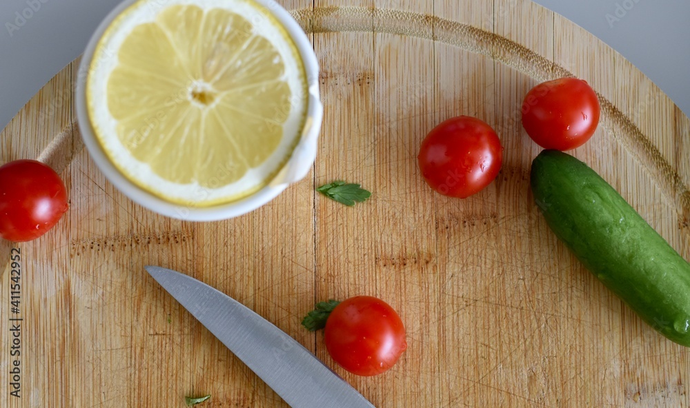 Making salad with lemon, tomatoes and cucumber at home Making salad with lemon, tomatoes and cucumber at home