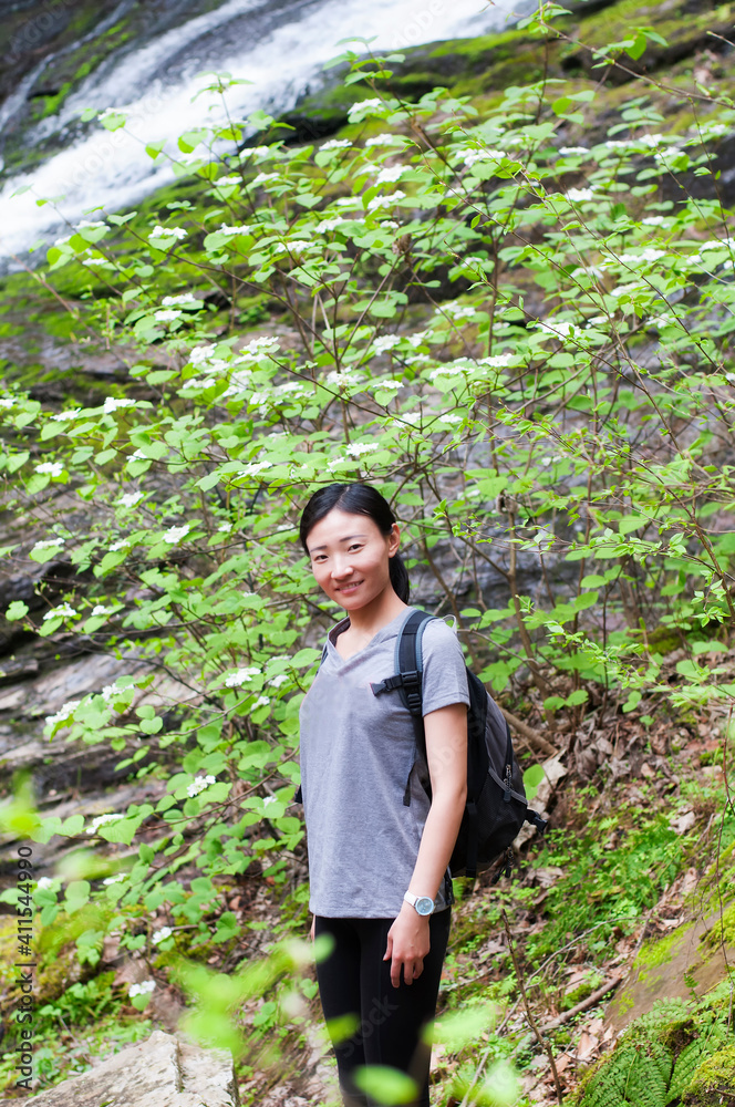 a happy chinese woman with waterfall background a happy chinese woman with waterfall background