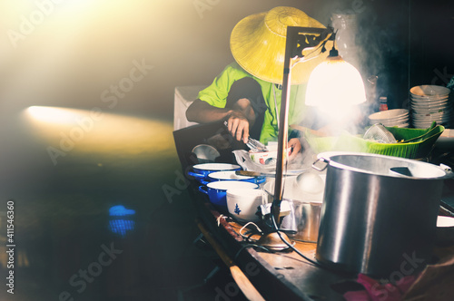 Photography A young man selling noodles on a boat