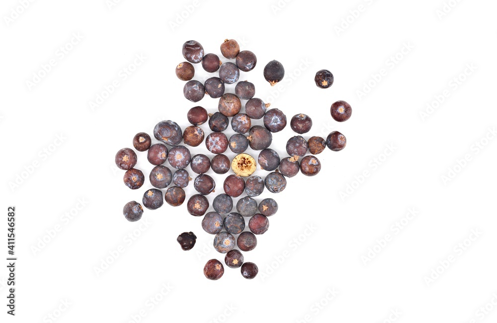 Dried juniper berries scattered on white background. One of them is halved. Top view. Dried juniper berries scattered on white background. One of them is halved. Top view.