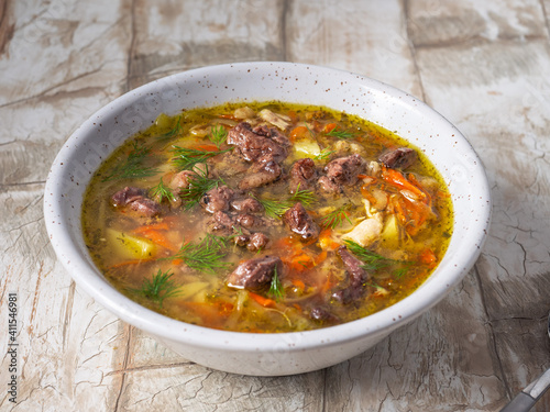 Konstfotografi Pickle soup with chicken giblets in a deep plate on the table