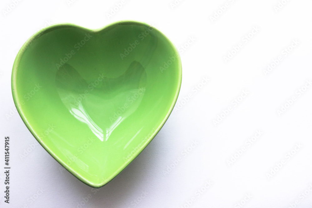Green empty Heart shaped bowl for healthy eating. Copy space for your text. Green empty Heart shaped bowl for healthy eating. Copy space for your text.