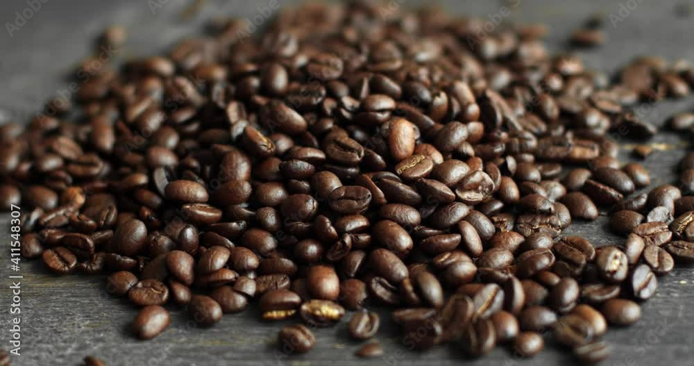 Roasted arabica coffee beans scattered on a wooden table. Fresh coffee beans. Espresso, americano, doppio, cappuccino, latte. Robusta. Selective focus. Roasted arabica coffee beans scattered on a wooden table. Fresh coffee beans. Espresso, americano, doppio, cappuccino, latte. Robusta. Selective focus.