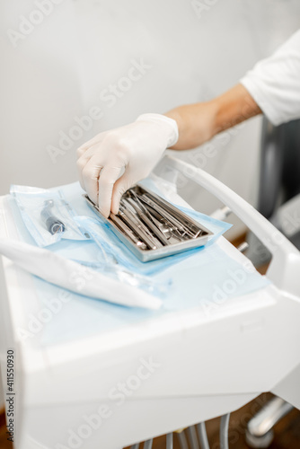 Dentist taking dental tools during a medical treatment, close-up on hand. High quality photo