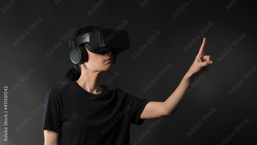 Girl with hands up wearing the VR headset goggles. Asian woman in glasses of virtual reality. The concept of futuristic. Digital VR glasses. Woman getting cyber experience using modern black color VR. Girl with hands up wearing the VR headset goggles. Asian woman in glasses of virtual reality. The concept of futuristic. Digital VR glasses. Woman getting cyber experience using modern black color VR.