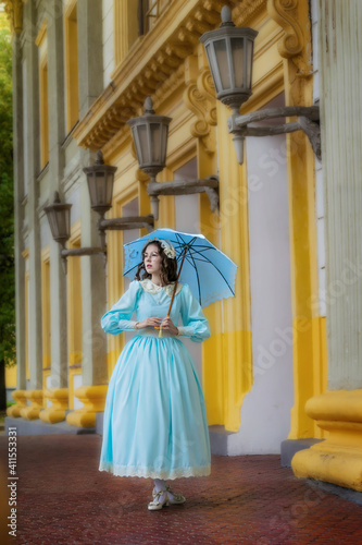 Girl in a vintage dress with an umbrella near mansion © Grigoriy Lukyanov