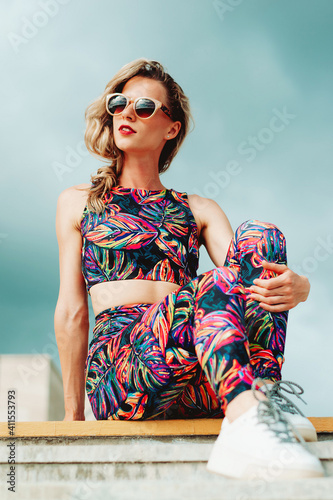 Beautiful blonde girl in glasses posing in trendy sportswear